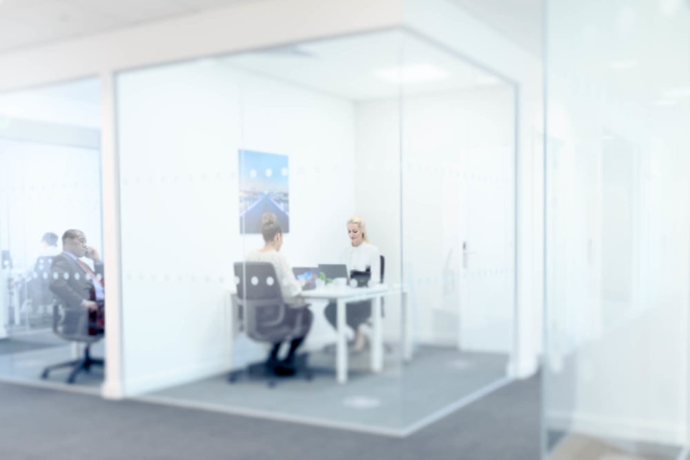 Corporate-photoshoot-mimecast-women-at-desks-in-glass-office