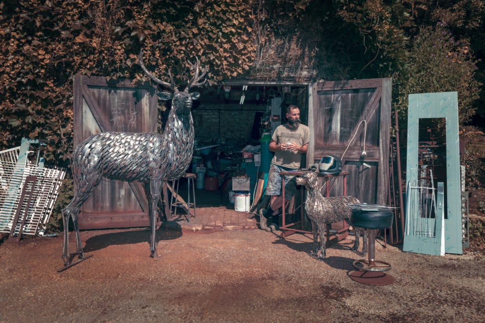 George Outside His Rustic Workshop With Some Of His Work